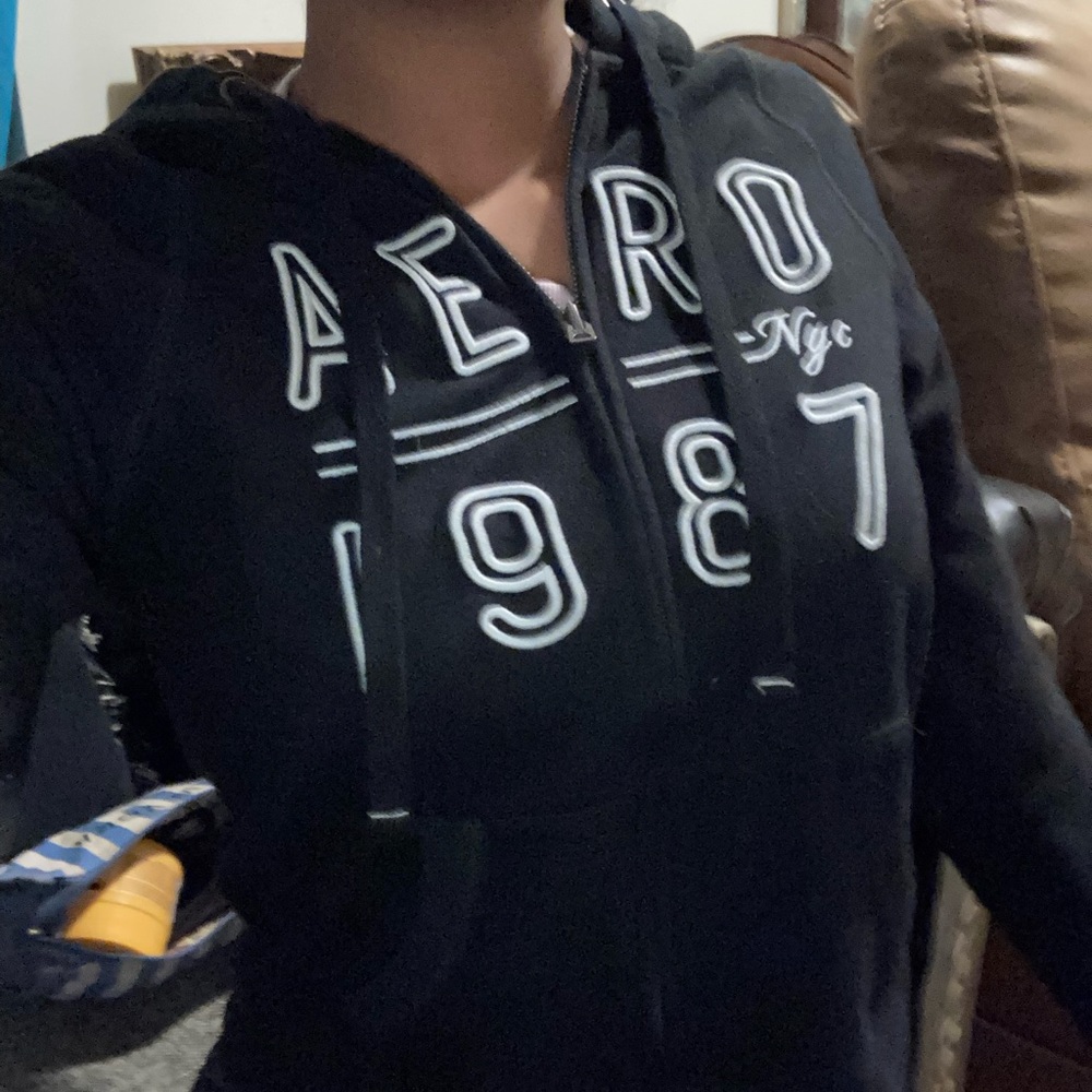 long sleeve black slip up sweater with lettering on the front, black and white